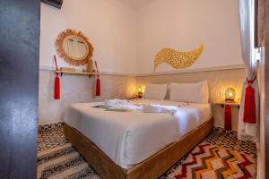 a bedroom with a large white bed in a room at Riad Jowara in Marrakech