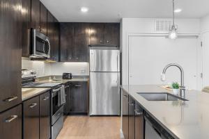 a kitchen with wooden cabinets and a stainless steel refrigerator at Luxury Home W Pool & Gym Mins To Baylor Hospital in Marble Falls