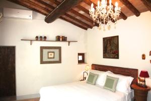 een slaapkamer met een bed en een kroonluchter bij Villa Organi in Vaiano