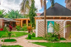 a house with a garden and palm trees at Namayani Safari Lodge in Arusha