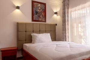 a bedroom with a bed with a painting on the wall at Namayani Safari Lodge in Arusha