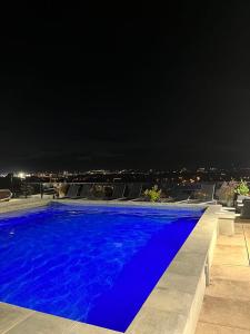 Ein Schwimmbad bei Nacht mit einer Stadt im Hintergrund in der Unterkunft Caïman 806 in Québec