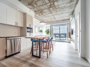 eine Küche mit Tisch und Stühlen und einem großen Fenster in der Unterkunft Caïman 806 in Québec