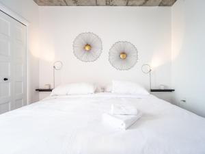 ein weißes Schlafzimmer mit einem großen weißen Bett und zwei Spiegeln in der Unterkunft Caïman 806 in Québec + 10 Fotos
