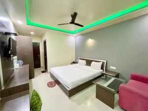 a bedroom with a bed and a tv and a couch at SEA VIEW- Family Hotel New T B- Resort inn, puri - near sea beach and Jagannath temple in Puri