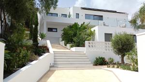 a white house with stairs and plants at Happyplace Malaga -- Villa with Panoramic Sea View Heated Infinity Saltwater Pool in Málaga