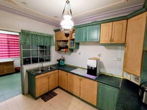 a kitchen with green cabinets and a sink at Homestay No. 8 in Segamat