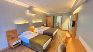 a hotel room with two beds and a television at Istankoy Hotel in Bodrum City +55 photos