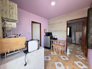a kitchen with purple walls and a table and a kitchen with a refrigerator at Serenity House 4B in Nathon Bay
