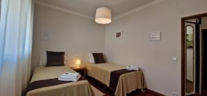 a small room with two beds and a mirror at Villa Papa João XXIII in Fátima