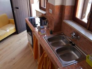 una cocina con fregadero y estufa en Il Nido del Lago del Turano, en Castel di Tora 24 fotos más