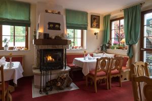 un restaurante con chimenea, mesas y sillas en Romantik Hotel Zum Lindengarten en Kurort Jonsdorf