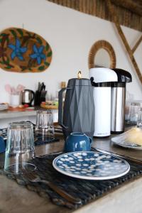 a kitchen counter with a table with plates and a coffee pot at Villa Beleza Prea Beachfront private room in Prea