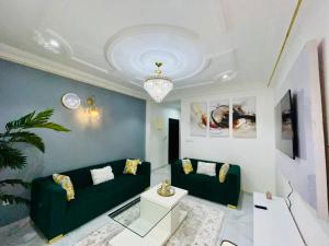 a living room with a green couch and a table at GodIsGood Residency in Yaoundé
