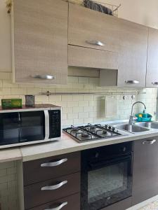 a kitchen with a microwave and a stove and a sink at Bellissima Mestre in Venice