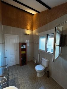 a bathroom with a toilet and a window at Solea Alcayna in La Alcayna +15 photos