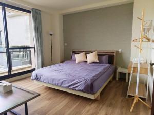 a bedroom with a purple bed and a large window at 芯禾慢旅-原禾恬cafe&bar in Puli