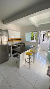 a kitchen with a counter and chairs in it at Residencial dos Ipês in Itacaré