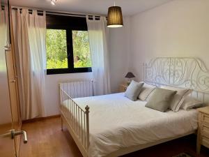 a bedroom with a white bed and a window at AIzaetxea in Jaca +27 photos