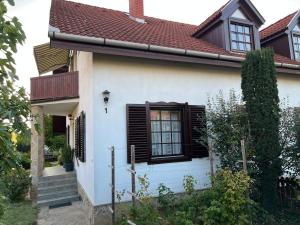 a white house with a black window and stairs at Apartment house Hévíz in Hévíz
