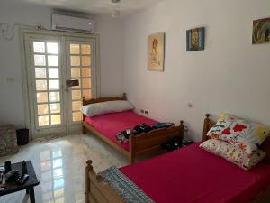 a room with two beds and a table and a window at North coast Great nightlife shoreside Marina AlAlamain مارينا الساحل الشمالي in El Alamein