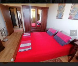 a bedroom with a red bed with a red blanket at apartment Marina hill in Chernomorets