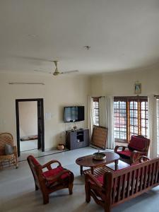 un salon avec une table et des chaises dans l'établissement Anagha Homestay Chikmagalur, à Chikmagalur