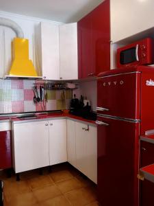 een rode keuken met witte kasten en een rode koelkast bij PolaPop Vacation in Santa Pola