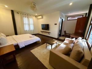 a living room with a couch and a bed at Roya Khmer House in Siem Reap