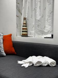 a bottle of beer sitting on a couch with towels at Gorgeous Holiday Home 5 minutes from Central London in London