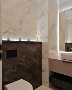 a bathroom with a white toilet and a sink at Onix Studio Infinity 801 in Văleni +19 photos
