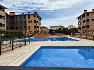a large swimming pool in front of some buildings at AIzaetxea in Jaca