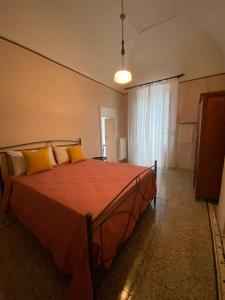 a bedroom with a bed with orange sheets and yellow pillows at Palazzotto Romantic in San Michele Salentino