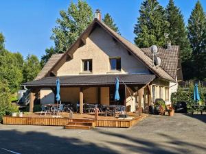 a house with a patio and tables and chairs at B&B Gite les Baudy in Le Haut-du-Them