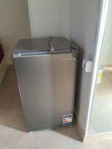 a small grey refrigerator in a corner of a room at Roma House in Aswan