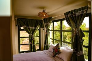 a bedroom with a bed and a large window at Farmhouse Loft Apartment at Mogador Essaouira  +29 photos