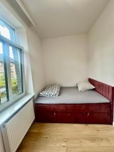 a small bed in a room with a window at Apartament mieszkanie blisko centrum nowe zadbane in Słupsk