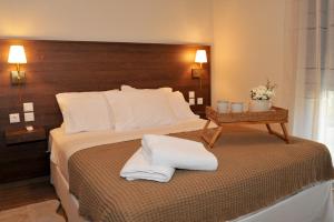 a hotel room with a bed with two towels on it at Meteora Guest Houses in Kalabaka