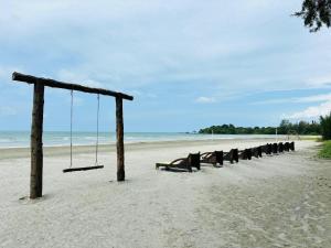 un columpio vacío en una playa de arena en Desaru Beach Luxury Suites Pool View 3Pax E1, en Bandar Penawar