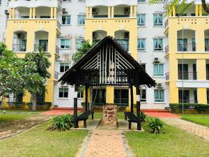 un banco en un parque frente a un edificio en Desaru Beach Luxury Suites Pool View 3Pax E1, en Bandar Penawar