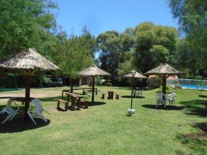 a park with tables and chairs and umbrellas at Hostería de los Césares in Merlo