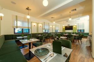 a dining room with tables and green chairs at Balcon Makrinitsa in Makrinitsa