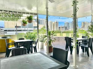 a patio with tables and chairs and a view of a city at Brisas Centro Historico in Santa Marta