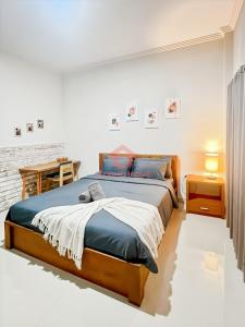 ein Schlafzimmer mit einem großen Bett und einem Tisch in der Unterkunft Cozy 1BR Uluwatu Room Pool in Uluwatu