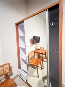 ein kleiner Tisch und Stuhl in einem Raum mit einem Kühlschrank in der Unterkunft Cozy 1BR Uluwatu Room Pool in Uluwatu