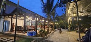 a person riding a bike in front of a building at Coco Retreat in Tân Phú
