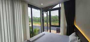Tân PhúCoco Retreat的一间带床的卧室，可欣赏阳台景色