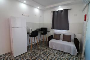 Habitación con cama, mesa y 2 taburetes en La Corte Trihouse 3 bedrooms, en Żabbar