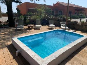 a large swimming pool with chairs and a table at Casa das Cucas in Pombal