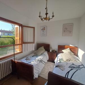 a bedroom with two beds and a window at Ezemil Etxea in Lumbier +17 photos